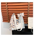 Dettaglio della borsa hobo con patchwork floreale, intrecciata, perle e fiocco decorativo - Bianco
