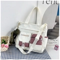 Dettaglio della borsa tote color-block con tasche funzionali e ciondolo a rana di peluche - Bianco Con Ciondolo