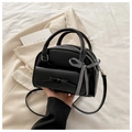 Detail of black PU leather shell bag featuring a bow pocket and checkered ribbon handle - Black