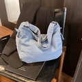 Borsa hobo in denim lavato blu con fibbia in metallo argento su seduta in pelle nera - Azzurro