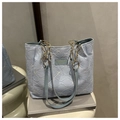 Détail de la broderie florale bleu clair du sac cabas avec sa bandoulière en chaîne dorée - Bleu