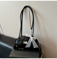 Detalle de bolso de hombro en piel negra brillante con lazo de encaje y logo metálico - Negro