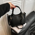 Bolso cubo negro de cuero granulado con herrajes dorados y adorno de perro - Negro