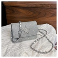 Close-up of silver sequin bag featuring a sparkling rhinestone star and metal chain strap - Silver