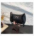 Chic black baguette shoulder bag featuring a prominent gold bow metal accessory - Black