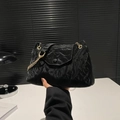 Schwarze Plissee-Tasche mit goldener Kette und strukturierter Stoff-Haptik im Detail - Schwarz