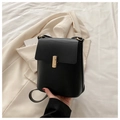 Minimalistische zwarte lederen crossbody tas met gouden gesp op beige blazer - Zwart