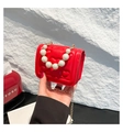 Detail of red quilted heart pattern bag with elegant pearl handle and gold chain strap - Red