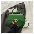 Detail of green trapezoid handbag featuring a gold circular hollow metal buckle - Green