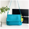 Detail of blue waterproof nylon crossbody bag featuring a yellow flower charm and side pocket - Blue (With Pendant)