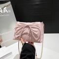 Bolso bandolera rosa estilo balletcore con lazo y cadena sostenido a mano - Rosa