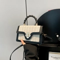 Schicke gewebte Tasche mit Farblock-Design und goldenem Blumenverschluss in Beige und Schwarz - Schwarz und Weiß