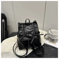 Mini black PU leather backpack with bow details and drawstring closure on a desk - Black