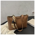 Detalle de bolso tote de cuero sintético marrón con un pañuelo de seda decorativo en el asa - Tostado