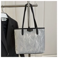 Detail van zilveren shopper met metallic crinkle textuur en zwart lederen hengsels - Grijs