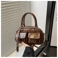 Nahaufnahme der braunen Lackleder-Boston-Tasche mit Cargotaschen und Silberbeschlägen - Kaffeebraun