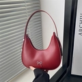 Elegant red crescent shoulder bag with metallic silver bow accent and minimalist design - Red
