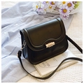 Detail of black crossbody bag featuring gold textured cylinder twist lock and stitching - Black