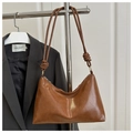 Détail d'un sac hobo marron en similicuir brillant avec une bandoulière nouée chic - Marron