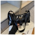 Nahaufnahme der schwarzen Lackledertasche mit goldener Schnalle und Nietendetails - Schwarz