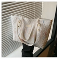 Detailed embroidery and embossed texture on a white leather tote bag with gold rivets - White
