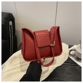 Close-up of red leather shoulder bag with woven texture and gold metal buckle detail - Red