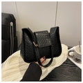 Close-up of black woven texture handbag with elegant gold metal buckle detail - Black