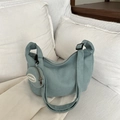 Hellblaue Shopper-Tasche mit Waffelstruktur und abnehmbarer Geldbörse auf weißem Bett - Grün