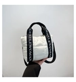 Close-up of white quilted puffer tote with black branded webbing handles and detachable strap - White