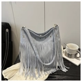 Dettaglio borsa tote in denim azzurro con lunghe frange e occhielli metallici dorati - Blu