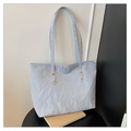 Detalle de bolso tote azul claro con textura plisada y remaches dorados de moda - Azul