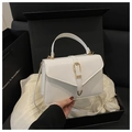 Detailansicht der weißen Lederhandtasche mit goldener Hufeisenschnalle in einer Geschenkbox - Weiß