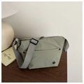 Borsa a tracolla verde salvia con tracolla regolabile e logo in metallo su tavolo di legno - Verde