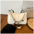Detailed macro view of white patent leather bag with silver butterfly chain and quilting - White