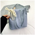Detail of light blue pleated shoulder bag with delicate white lace bow accessory - Blue