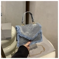 Detail of light blue denim crossbody bag featuring fringe edges and golden chain strap - Blue