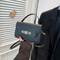 Bolso de mano clásico en cuero negro mate con cierre de cadena dorada y asa curvada - Negro