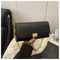 Close-up of black crocodile embossed leather texture with large gold metal buckle - Black