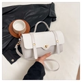 Detailaufnahme der weißen Ledertasche mit gewebter Klappe und goldenem Drehverschluss - Weiß