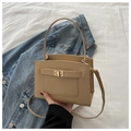 Chic beige crossbody bag with gold twist lock on stylish white fabric background - Khaki