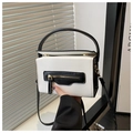 Detail view of the black and white contrasting crossbody bag with gold-tone hardware zipper - White