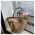 Close-up of woven straw tote bag with lace bow and brown handles on window sill - Khaki With Silk Scarf