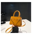 Vue détaillée du sac à main en cuir jaune avec boucles décoratives et poignée haute - Marron