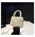 Dettaglio della borsa in pelle color crema con hardware dorato e logo sulla parte frontale - Bianco