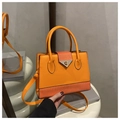 Orange crossbody bag with textured leather stitching and golden buckle on display pedestal - Orange
