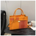 Detail of orange crocodile pattern patchwork tote with golden metal twist lock closure - Orange