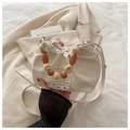 Chic beige pleated bucket bag featuring amber-textured bead handle and drawstring closure - White