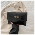 Black crocodile pattern envelope clutch with a golden metal bow decoration - Black
