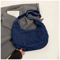 Detalle de bolso hobo denim azul oscuro con correa ajustable sobre chaqueta gris - Azul oscuro