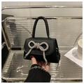 Detail of black mini crossbody bag featuring a sparkling silver rhinestone bow decoration - Black